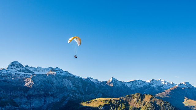 Paraglider die over de Alpen vliegt